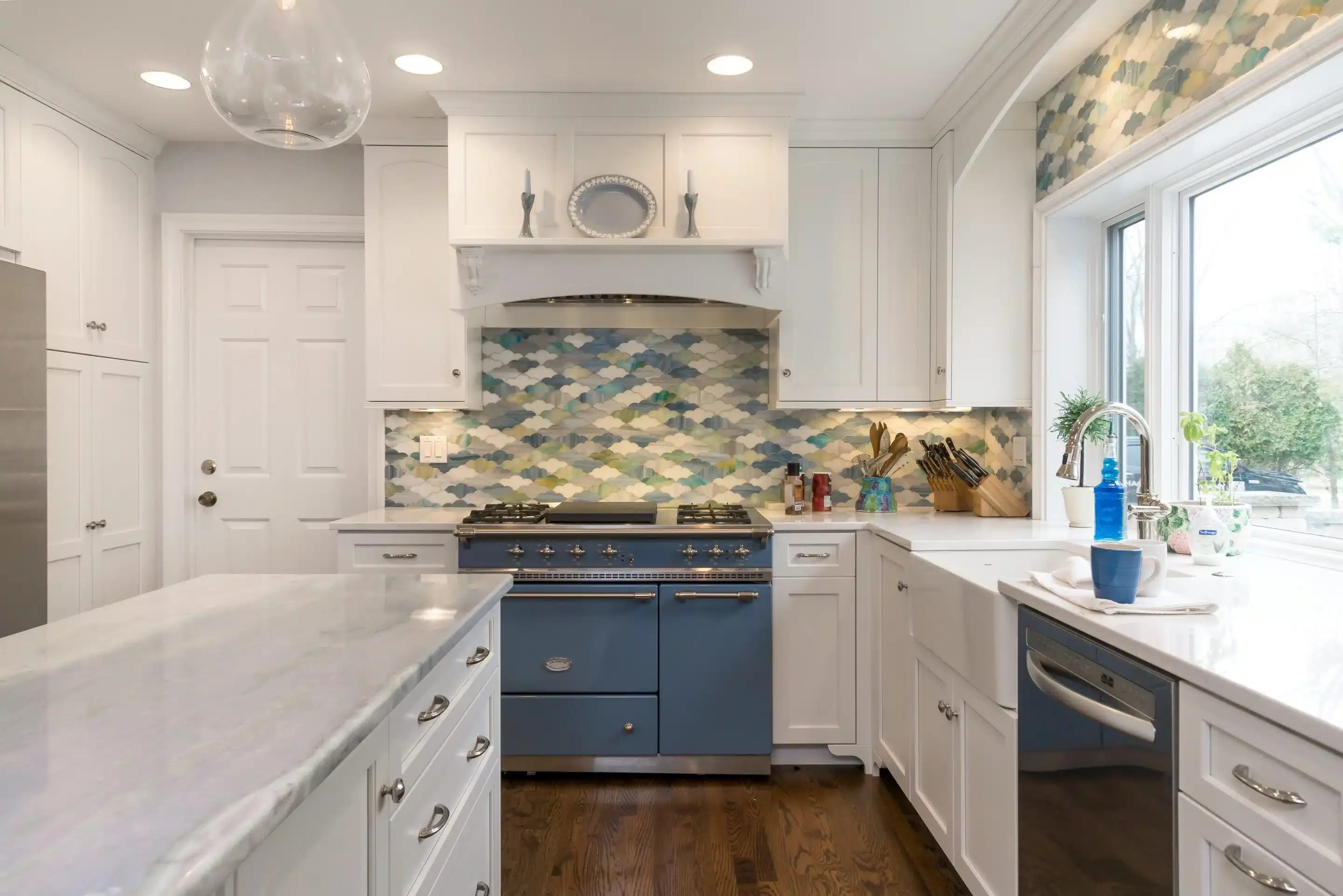 pepper pike kitchen remodel with blue and green backsplash, white cabinets, and a kitchen island